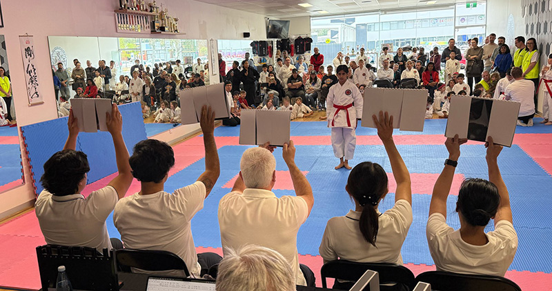 Kata judges presenting their scores to both the competitor and the audience at the Phillip Cup.