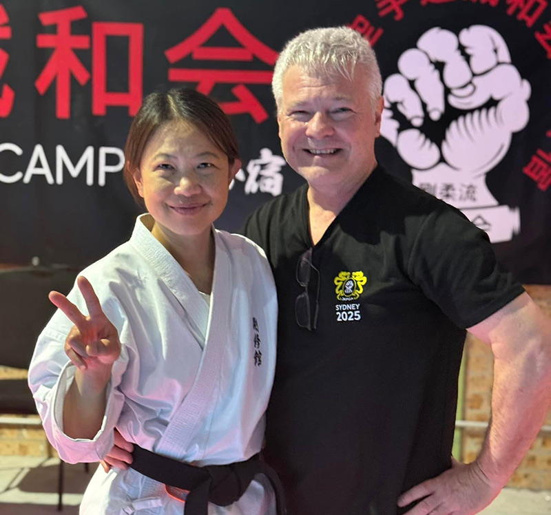 Toy Drake beams with joy after receiving her score at her Nidan (2nd Dan Black Belt) grading, pictured with her husband, Andrew Drake.